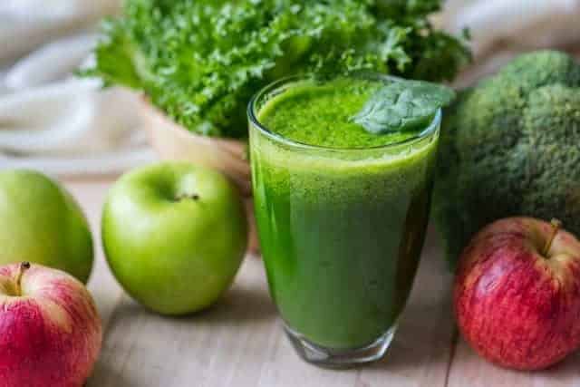 warzywny, zielony koktajl w szklance, obok jabłka