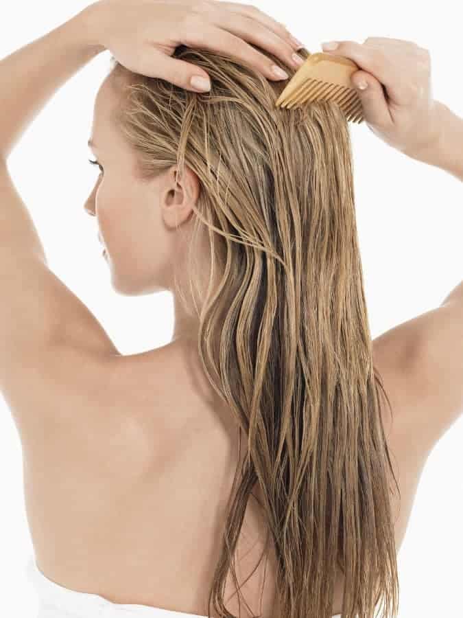 kobieta czesze umyte włosy