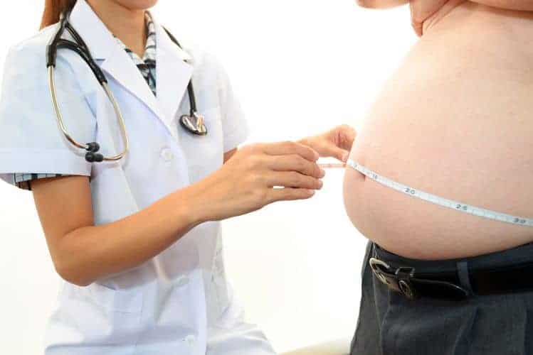 lekarz mierzy obwód brzucha otyłego mężczyzny