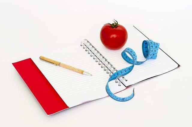 notes, długopis, miarka krawiecka i pomidor