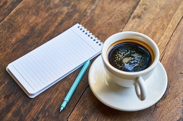 filiżanka z kawą, notatnik, długopis