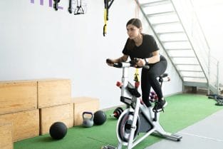 kobieta trenuje na rowerze stacjonarnym